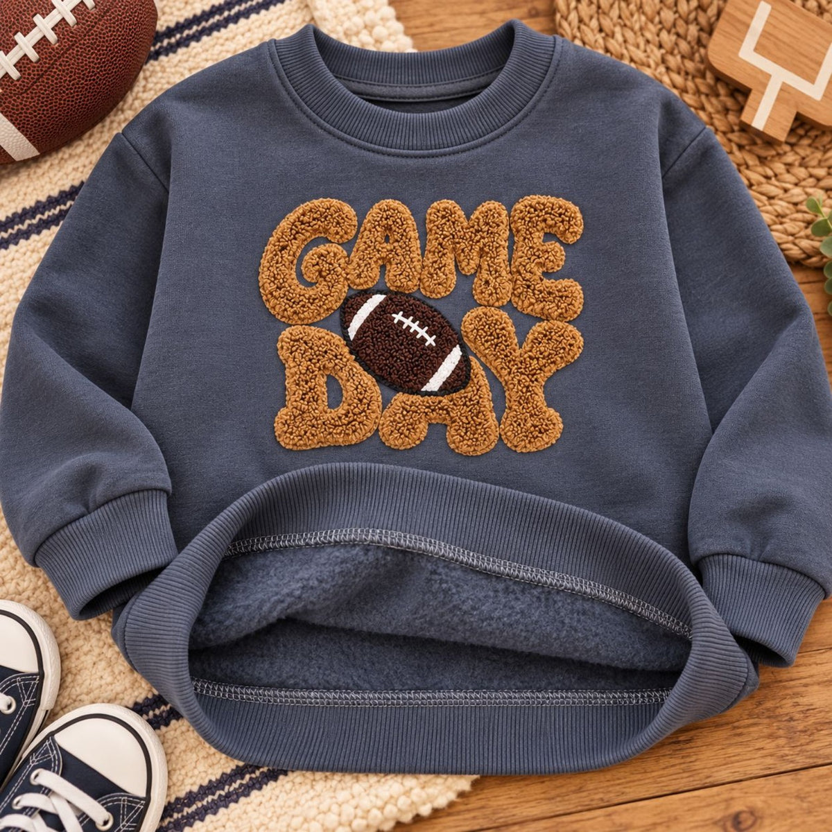 Close-up of raised textured GAME DAY football sweatshirt design and warm fleece lining