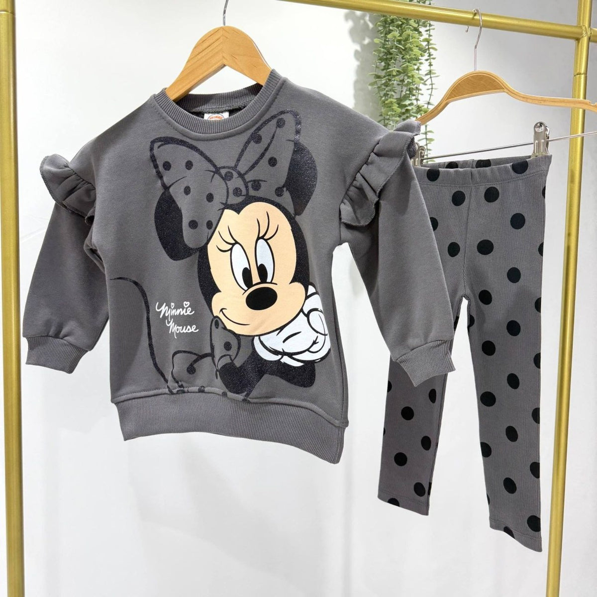 Grey Minnie Mouse sweatshirt and leggings displayed on hangers
