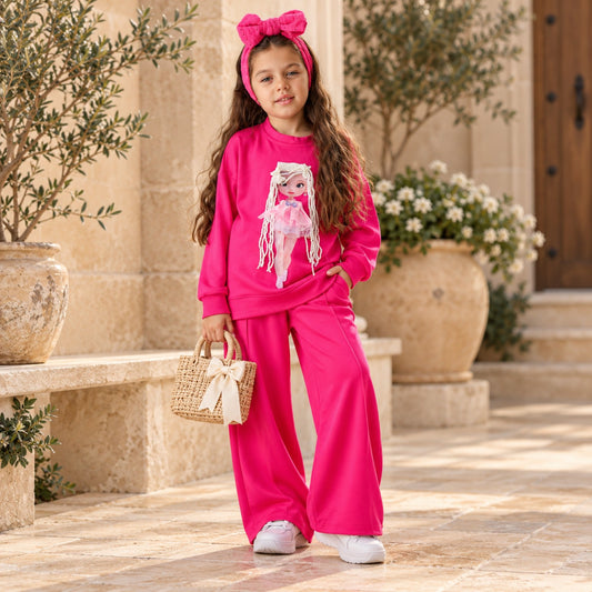 Girl wearing hot pink 3D doll sweatshirt and matching wide-leg pants outdoors, full-length view