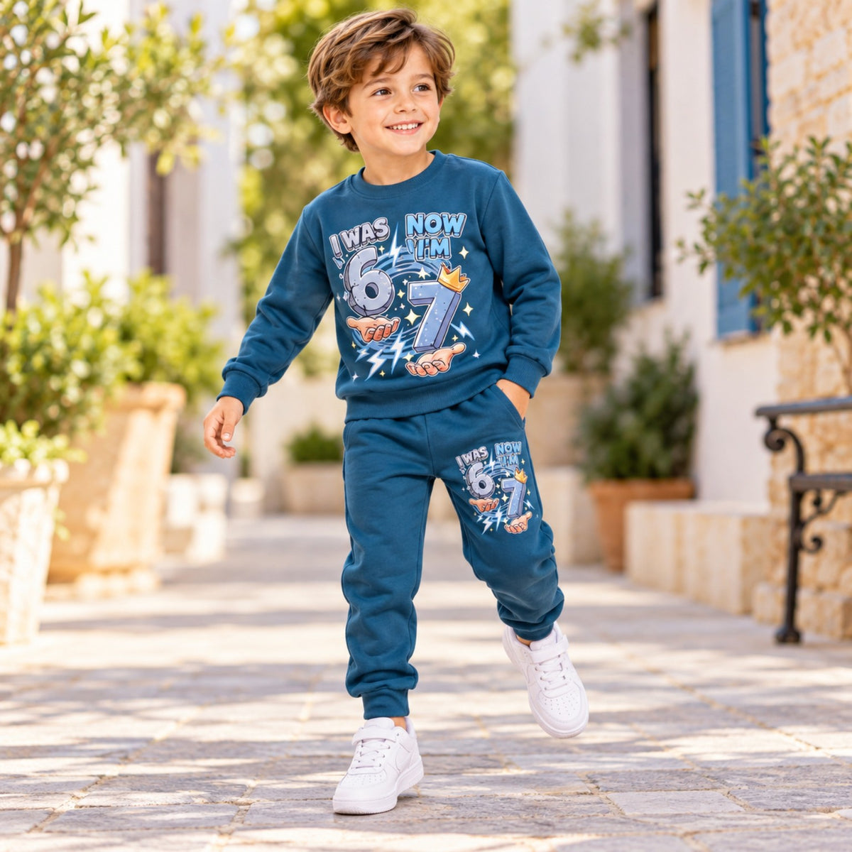 Boy wearing blue 7th birthday sweatshirt and joggers outfit outdoors, full-length walking pose