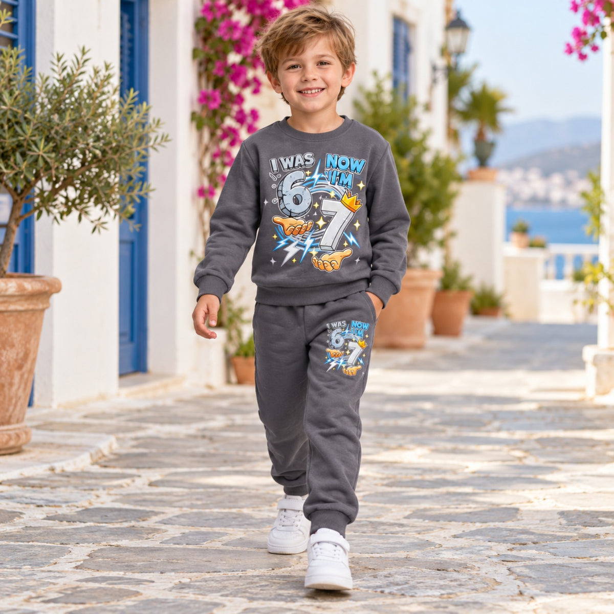 Boy walking in grey seventh birthday sweatshirt and joggers set with number 67 print