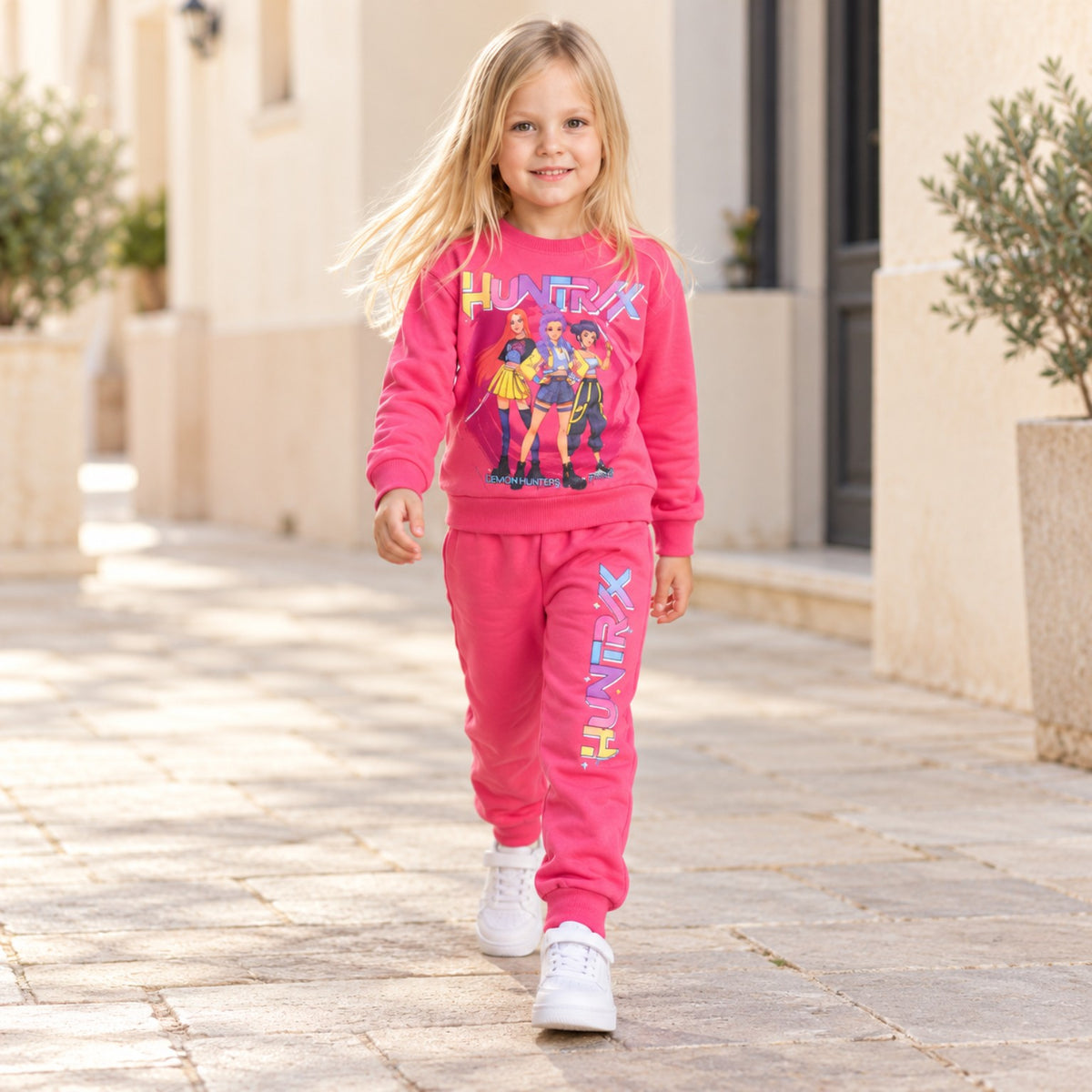 Girl walking outdoors in pink HUNTR/X K-pop sweatshirt and jogger pants