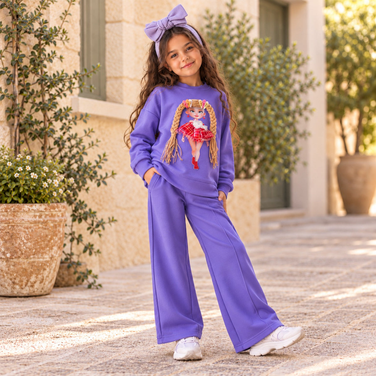 Girls violet two-piece outfit with long sleeve doll sweatshirt and matching trousers, lifestyle photo