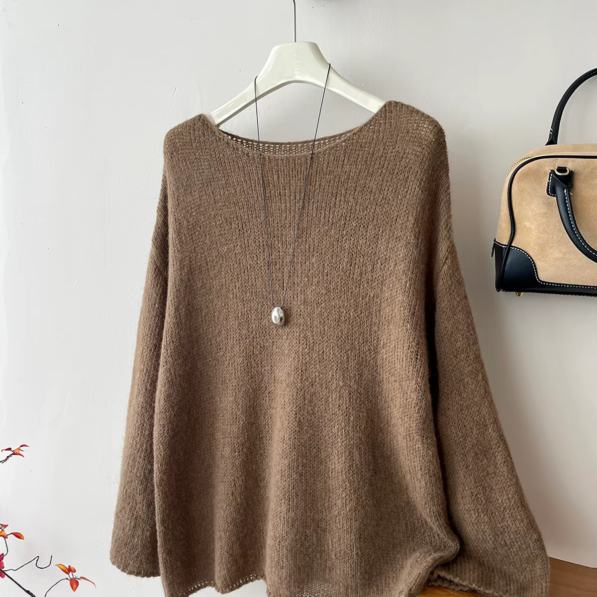 Taupe knit sweater with necklace in boutique display, original product view