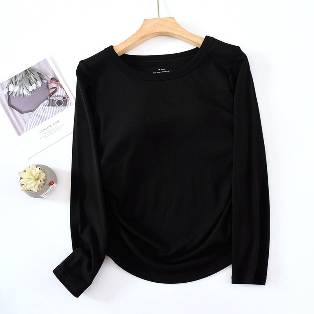 Black long-sleeve top, front flat lay