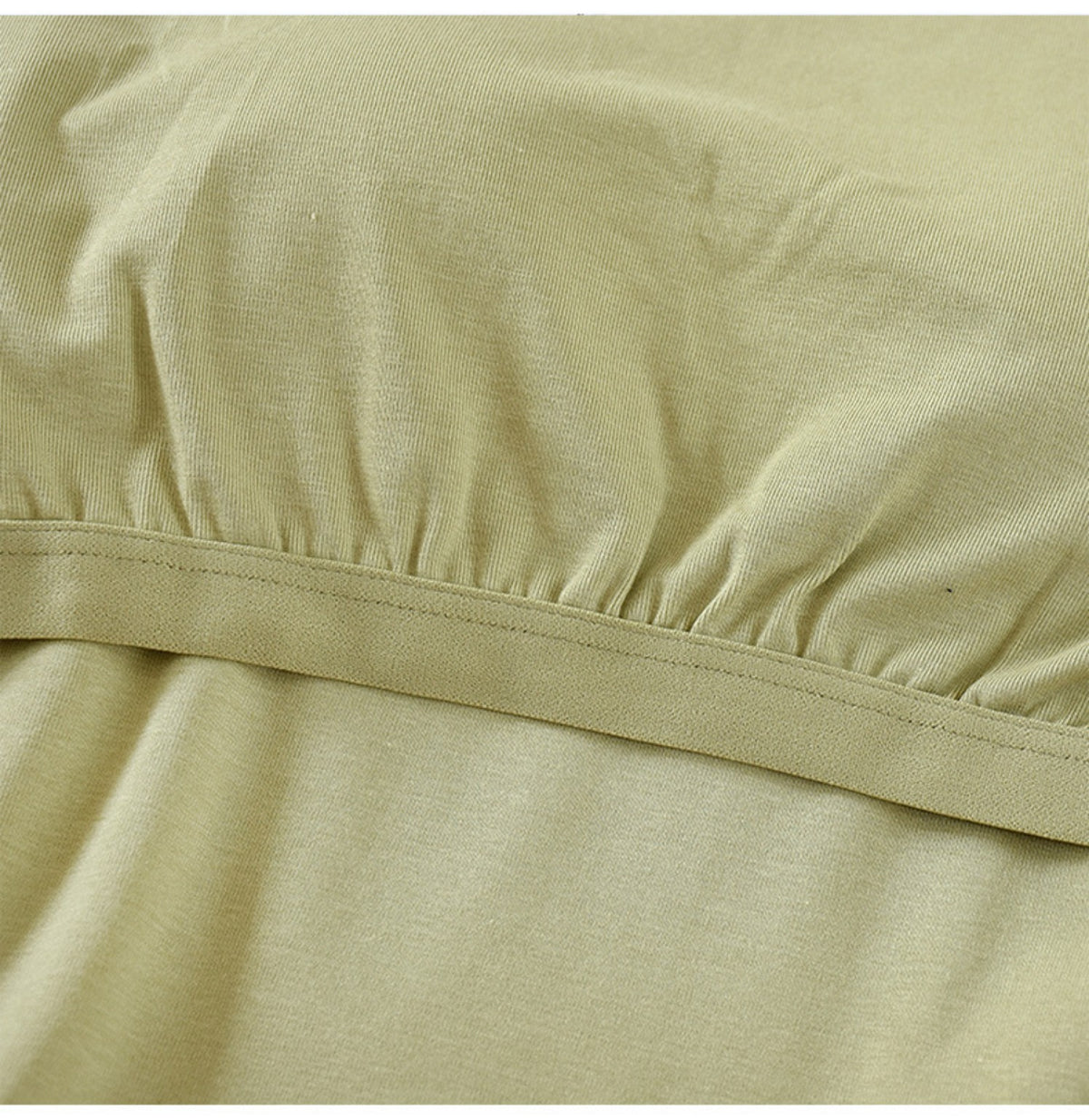 Close-up of soft fabric and band of sage green top